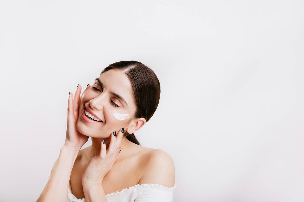 Woman applying tissue oil on face for glowing skin showing benefits of tissue oil on face