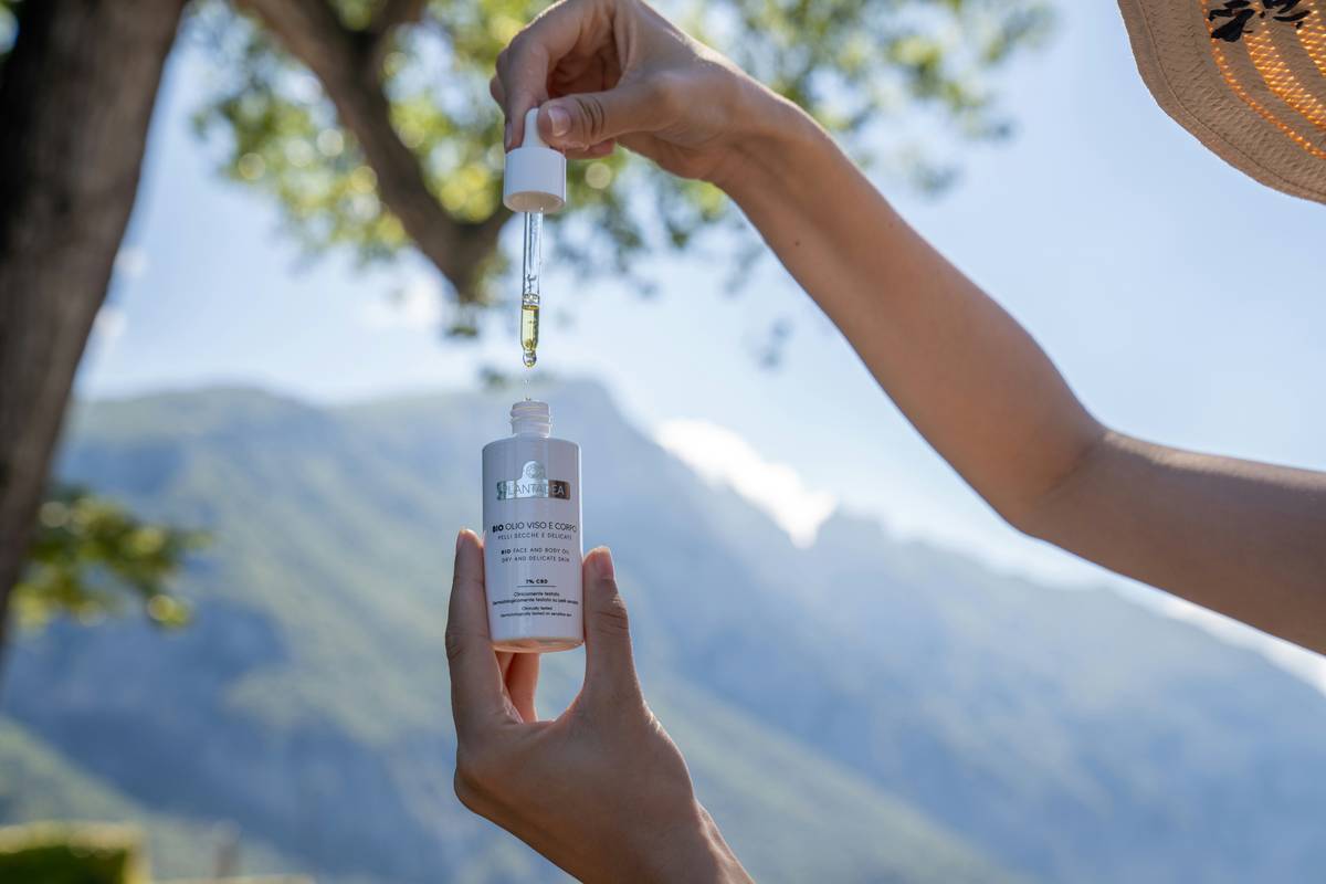 close-up of skincare oil face is bio good bottle with dropper on marble surface